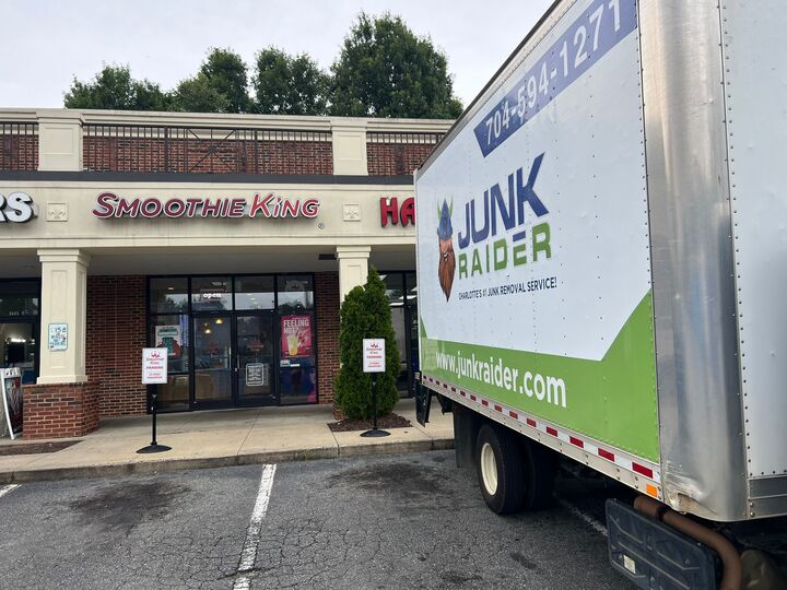 Junk Raider team lifting heavy junk items in Greensboro